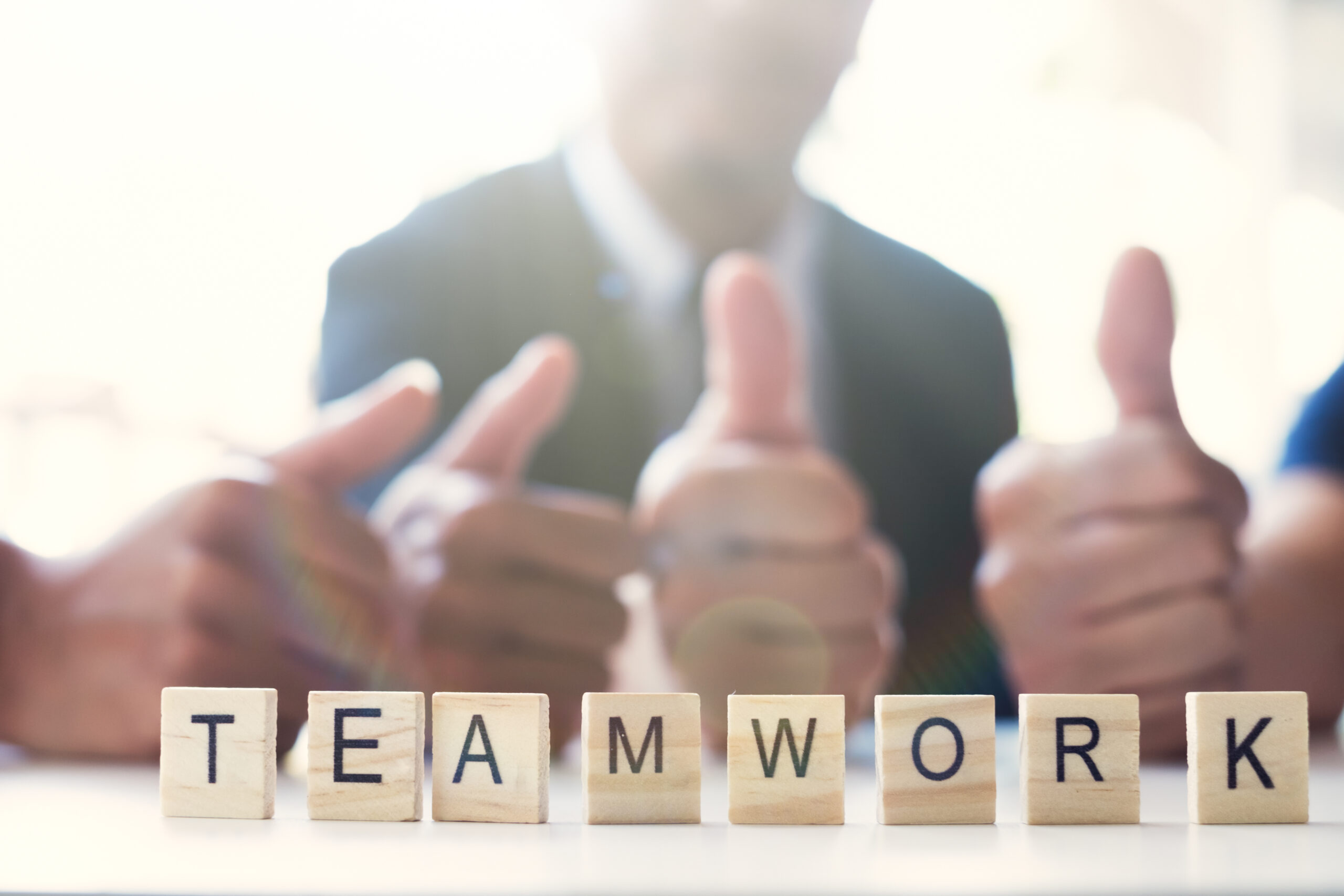 “Teamwork” word on business working table. Wooden cross word alphabet “Teamwork”. Business teamwork concept.